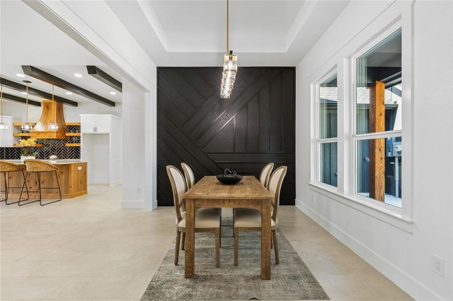 Dining room featuring a raised ceiling and wood walls