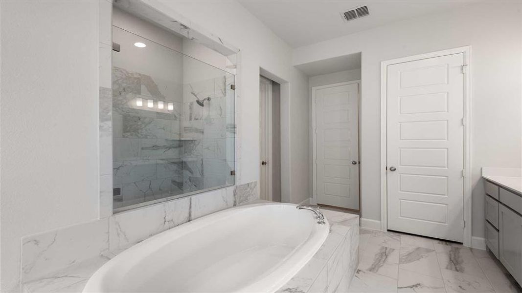 Bathroom with tile patterned flooring, shower with separate bathtub, and vanity