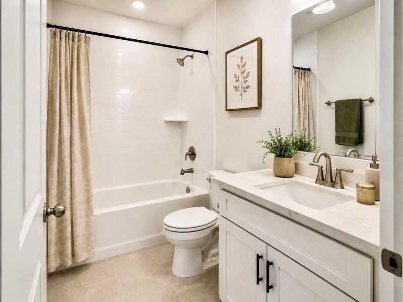 This first-floor full bathroom includes a tub/shower combo and is conveniently located near the main living areas for easy access from the kitchen, dining, and living spaces. Its placement adds everyday functionality to the first floor and provides a practical layout for the home. * Photo rendering shown as home is currently under construction | Final appearance may vary *
