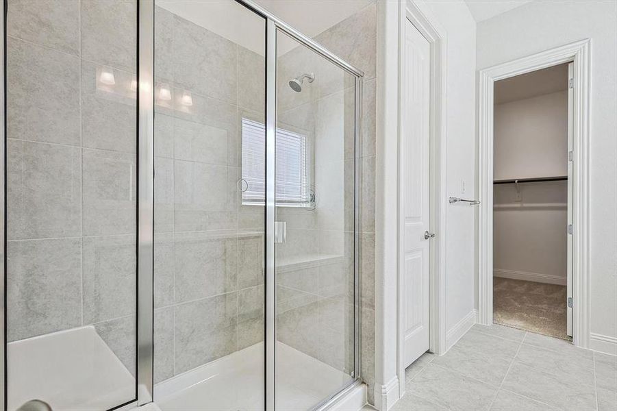 Bathroom with walk in shower and tile patterned floors