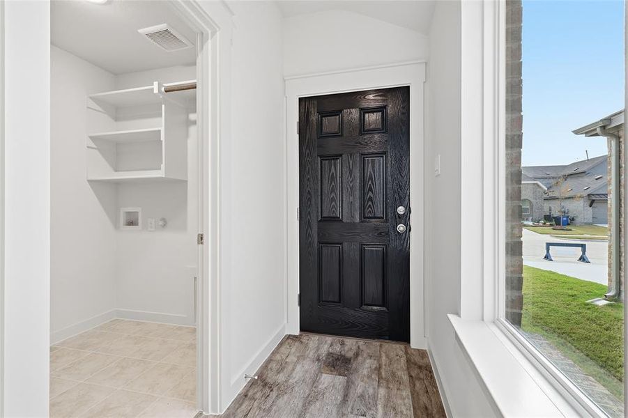 Washroom with light wood-style floors, lofted ceiling, and washer hookup Washroom with light wood-style floors, lofted ceiling, and washer hookup