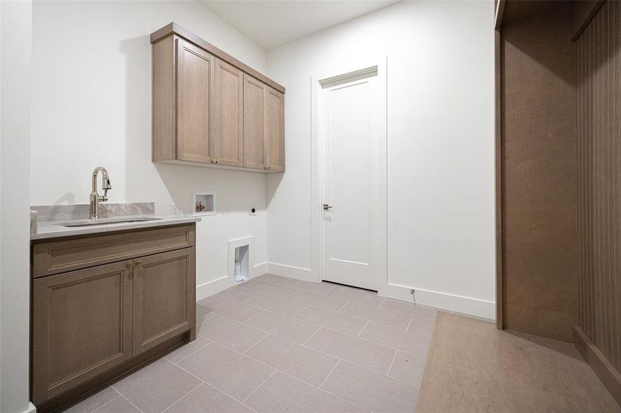 Laundry room featuring electric dryer hookup, cabinet space, washer hookup, and light tile patterned flooring Laundry room featuring electric dryer hookup, cabinet space, washer hookup, and light tile patterned flooring