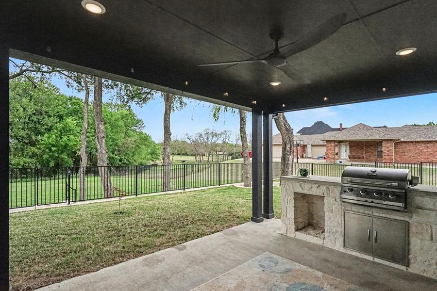 Fenced backyard with area for grilling, a patio area, and a ceiling fan