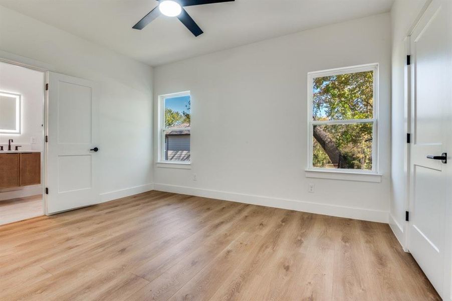Empty room with light wood-style floors and ceiling fan