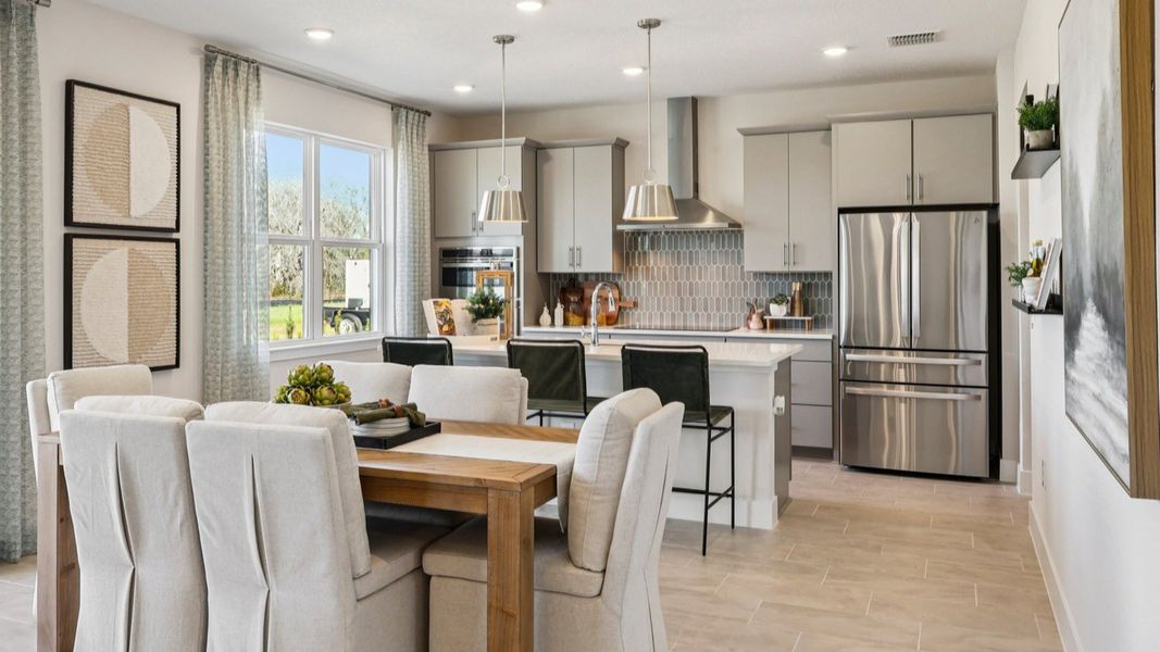 The Mangrove Model Open Concept Kitchen and Dining Area at Lakeside at Satilla by DRB Homes in Saint Cloud, FL