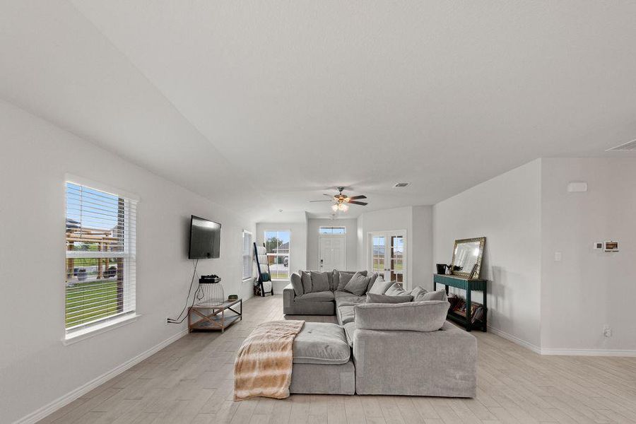 Living room with light wood finished floors and ceiling fan