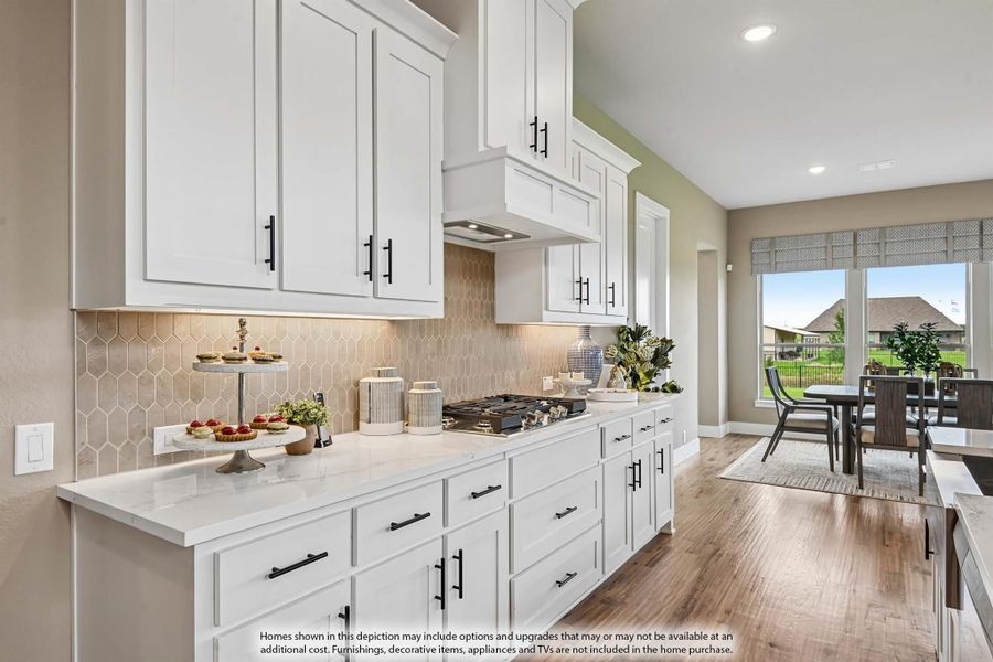 Kitchen with white cabinets, quartz countertops, tile backsplash, and gas cooktop open to dining area with hardwood floors Kitchen with white cabinets, quartz countertops, tile backsplash, and gas cooktop open to dining area with hardwood floors
