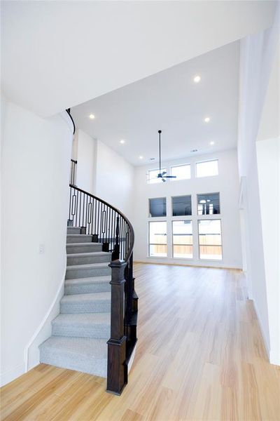 Stairs featuring wood finished floors, recessed lighting, and a ceiling fan Stairs featuring wood finished floors, recessed lighting, and a ceiling fan