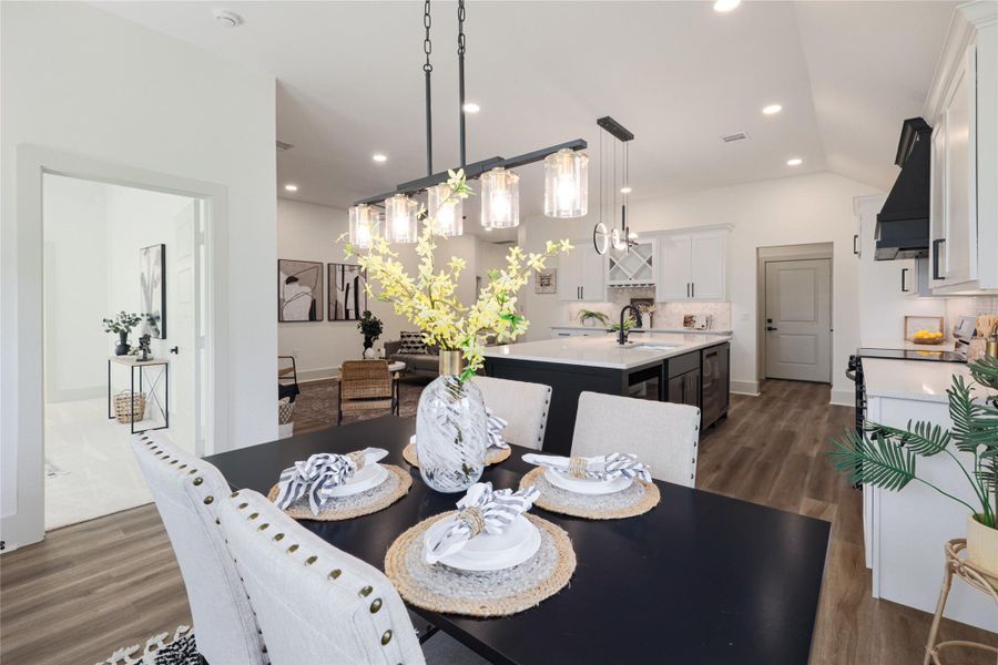 Dining space with dark wood finished floors, recessed lighting, and vaulted ceiling