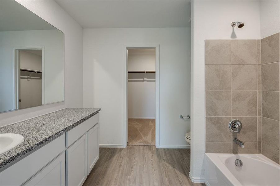 Bathroom featuring hardwood / wood-style floors, vanity, and toilet