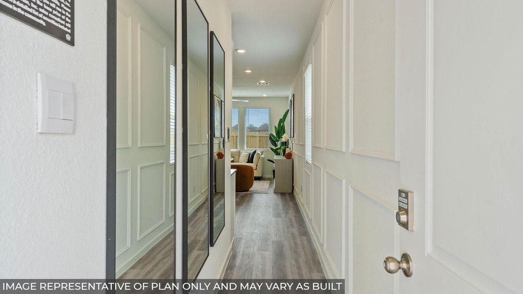 Entryway featuring decorative wall paneling, recessed lighting, wood-finish flooring, and a contemporary door handle