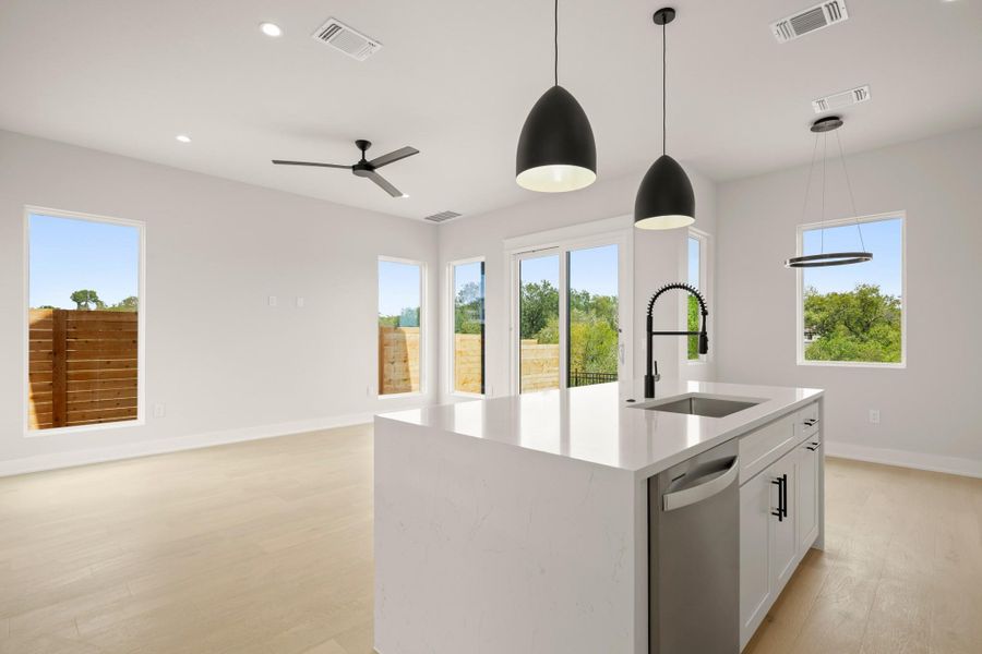 Kitchen with white cabinets, light stone countertops, healthy amount of natural light, and recessed lighting Kitchen with white cabinets, light stone countertops, healthy amount of natural light, and recessed lighting
