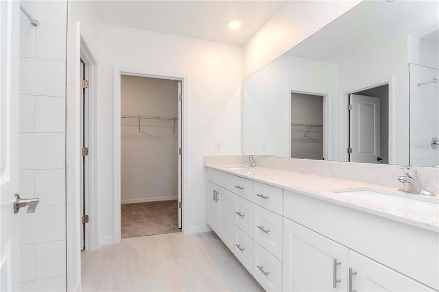 Owners Bathroom with Dual Sinks large counter space and walk in closet