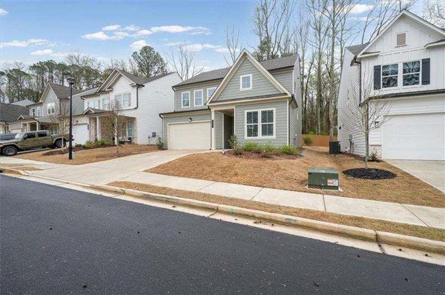 Front exterior of a new home in Enclave at Edgewater, Holly Springs, GA, highlighting curb appeal (Image 25). Front exterior of a new home in Enclave at Edgewater, Holly Springs, GA, highlighting curb appeal (Image 25).