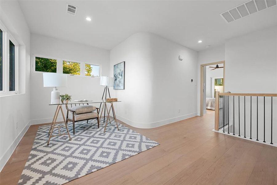 Living area with recessed lighting and light wood-style flooring