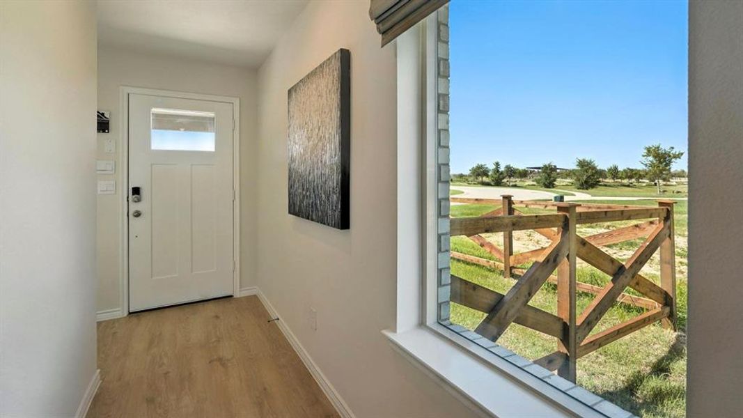 Entryway with baseboards and wood finished floors