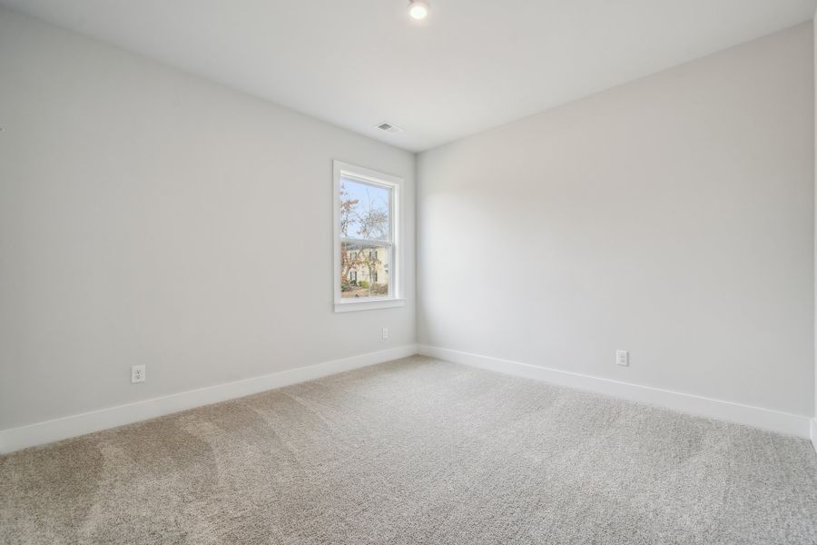 A room with a window and carpet.