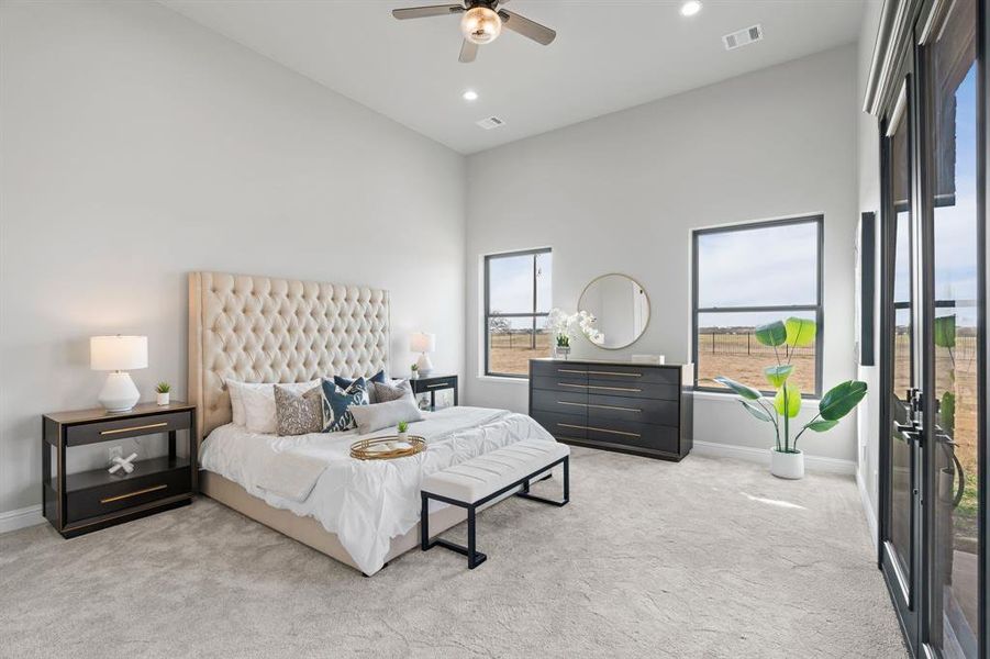 Carpeted bedroom with ceiling fan and high vaulted ceiling