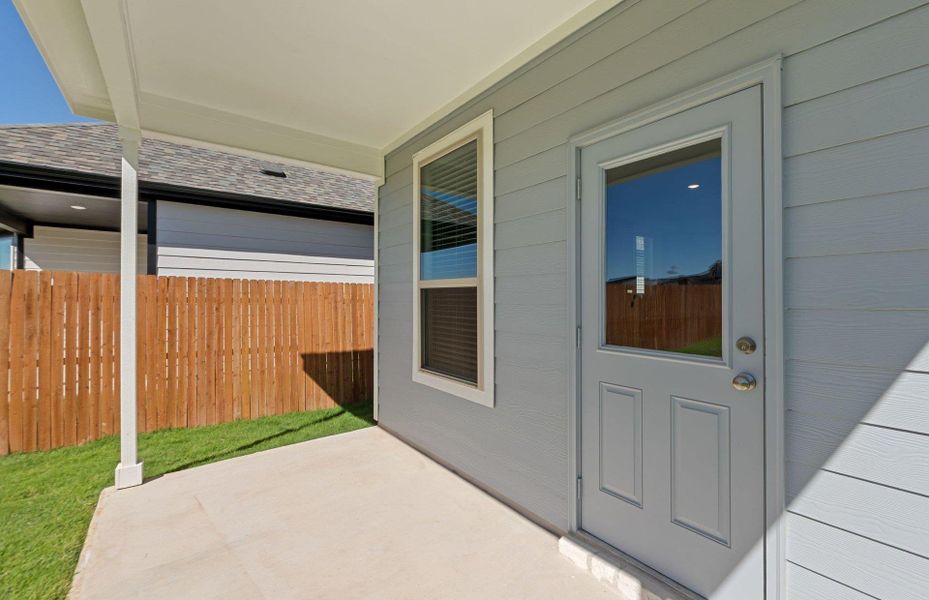 Doorway to property featuring roof with shingles and a patio area Doorway to property featuring roof with shingles and a patio area