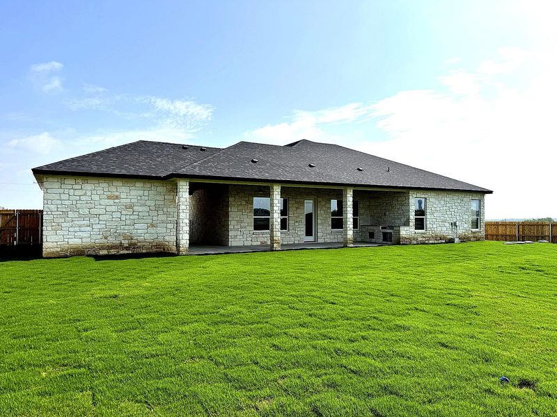 A spacious backyard with vibrant green grass and a welcoming patio space, perfect for outdoor living. A spacious backyard with vibrant green grass and a welcoming patio space, perfect for outdoor living.