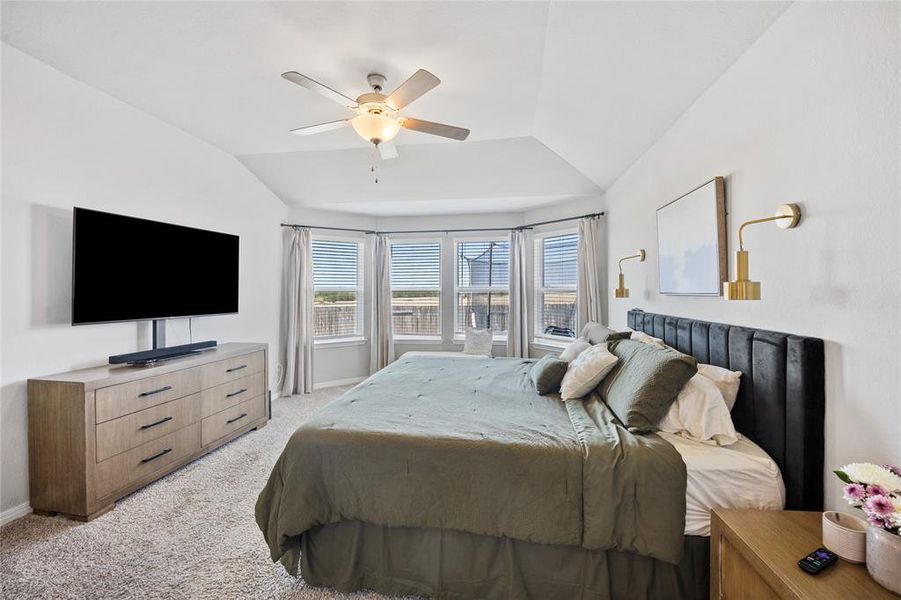 Bedroom with light carpet, vaulted ceiling, and a ceiling fan