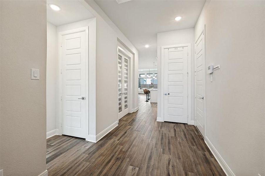 Hallway featuring wood-finish flooring, recessed lighting, shaker-style doors, and baseboard molding