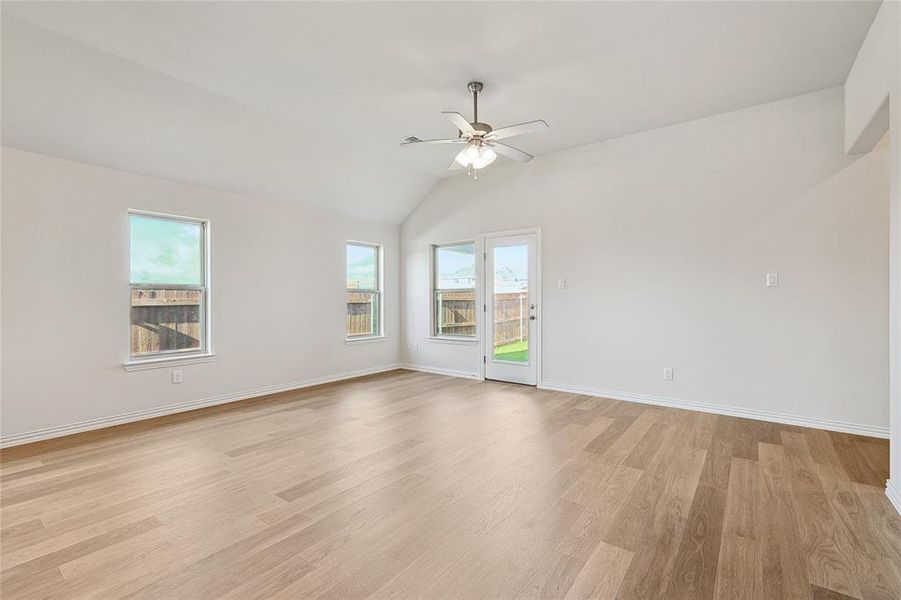 Unfurnished room featuring ceiling fan, light hardwood / wood-style flooring, and lofted ceiling