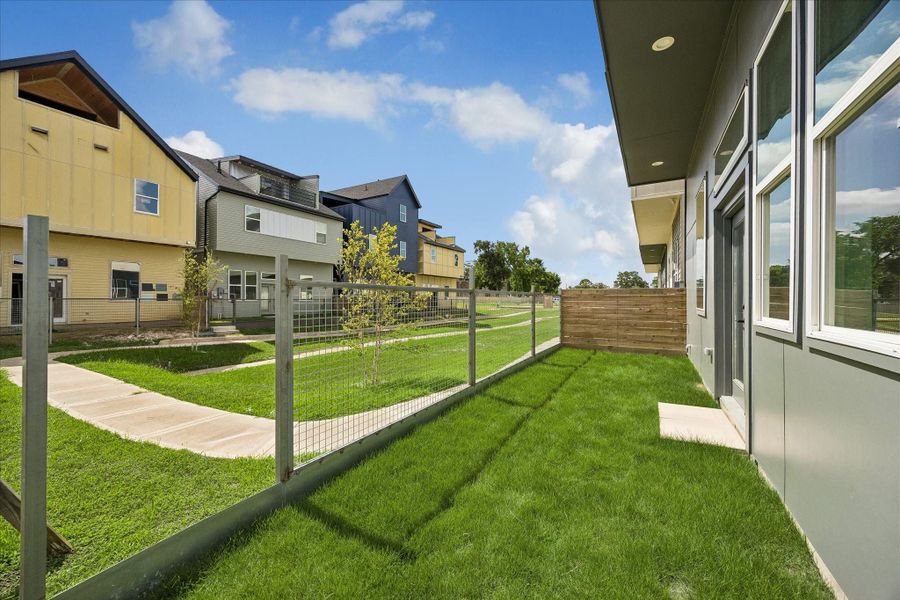 Private backyard featuring a fenced lawn, outdoor living space, and convenient access to the community's landscaped common areas. Private backyard featuring a fenced lawn, outdoor living space, and convenient access to the community's landscaped common areas.