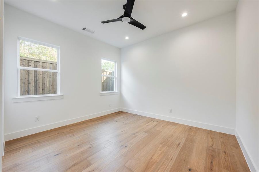Guest bedroom featuring light wood-style floors, recessed lighting, and a ceiling fan Guest bedroom featuring light wood-style floors, recessed lighting, and a ceiling fan