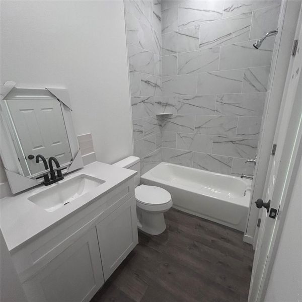 Full bathroom with dark wood-type flooring, bathtub / shower combination, and vanity Full bathroom with dark wood-type flooring, bathtub / shower combination, and vanity