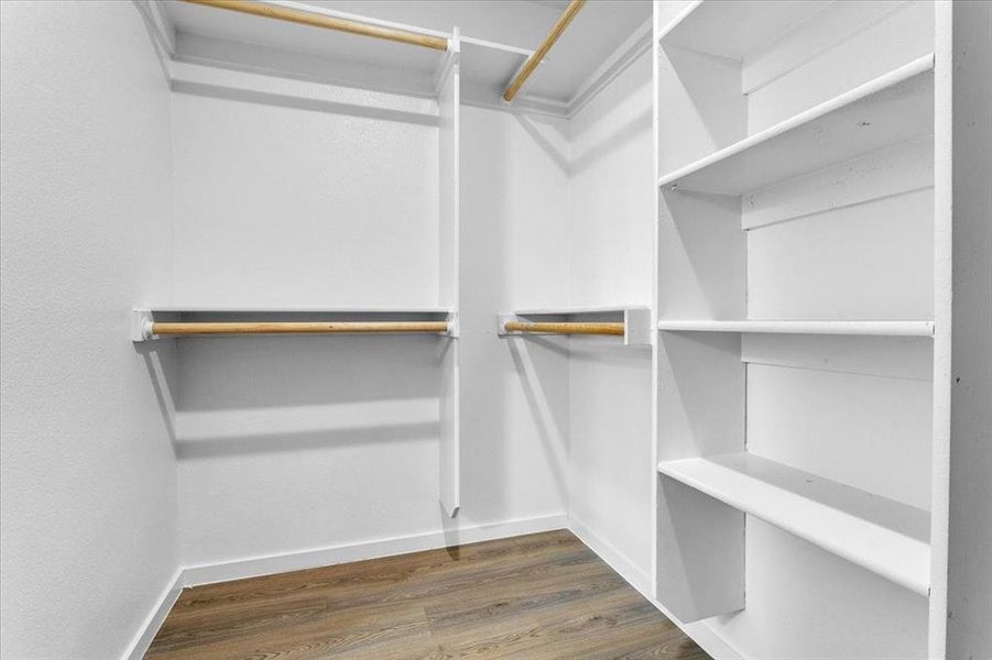 Walk in closet with dark hardwood / wood-style floors