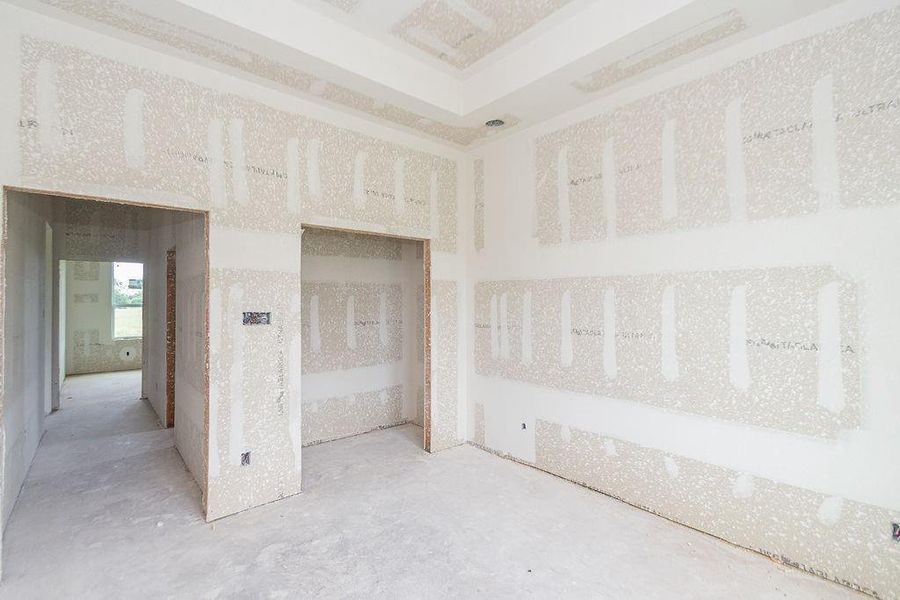 Spacious unfinished bedroom with drywall installed, featuring high ceilings and potential for customization. Spacious unfinished bedroom with drywall installed, featuring high ceilings and potential for customization.