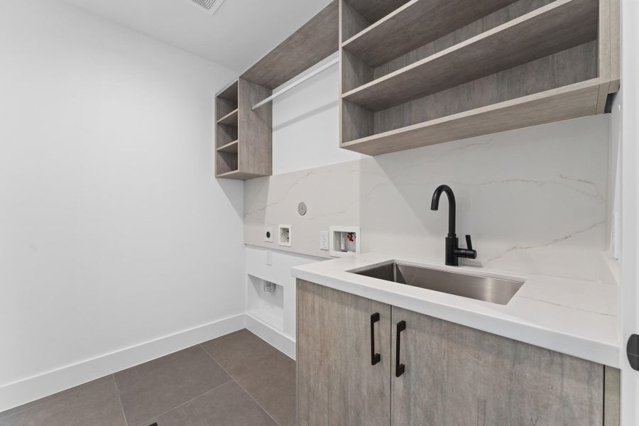 A spacious laundry zone finished with quartz counters, under-mount sink, and smart upper storage — the everyday, elevated. A spacious laundry zone finished with quartz counters, under-mount sink, and smart upper storage — the everyday, elevated.