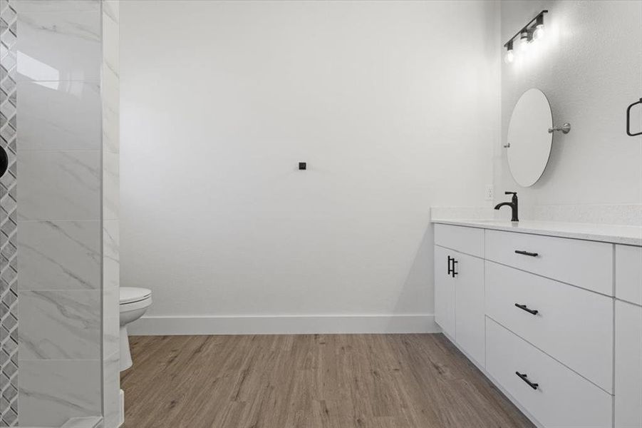 Bathroom featuring vanity, toilet, and hardwood / wood-style floors