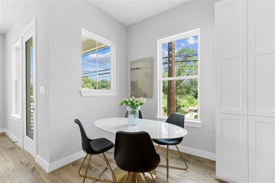 The dedicated breakfast nook, bathed in abundant natural light from the surrounding windows, offers a luminous start to every morning.