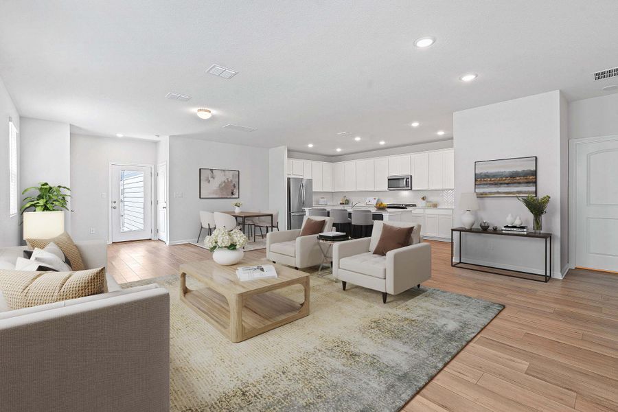 An inviting open-concept living area boasts light hardwood flooring and seamless transitions between kitchen, dining, and relaxation zones. An inviting open-concept living area boasts light hardwood flooring and seamless transitions between kitchen, dining, and relaxation zones.