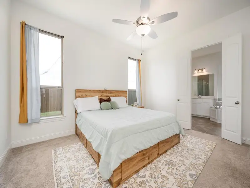 Bedroom with multiple windows, baseboards, and carpet