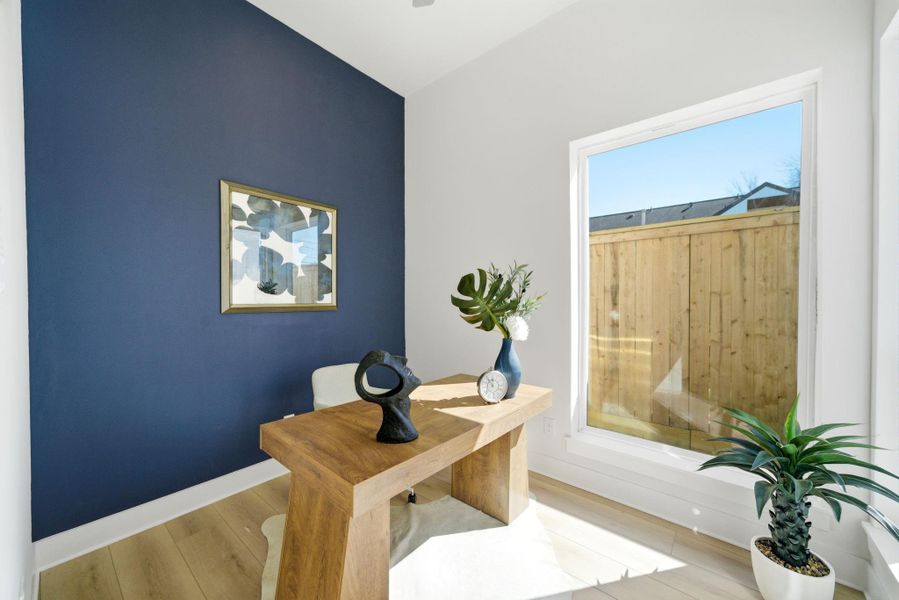Work here in peace. This bright home office (4th Room!!!) features a modern design with a large window providing ample natural light and a navy accent wall adding a sophisticated touch.