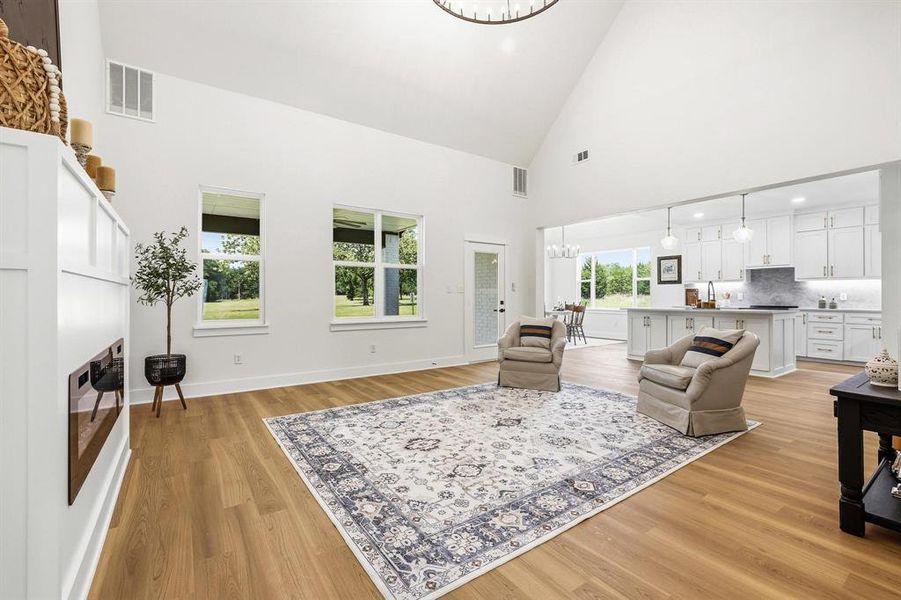 Open-concept living area with vaulted ceilings and wood-finish flooring Open-concept living area with vaulted ceilings and wood-finish flooring