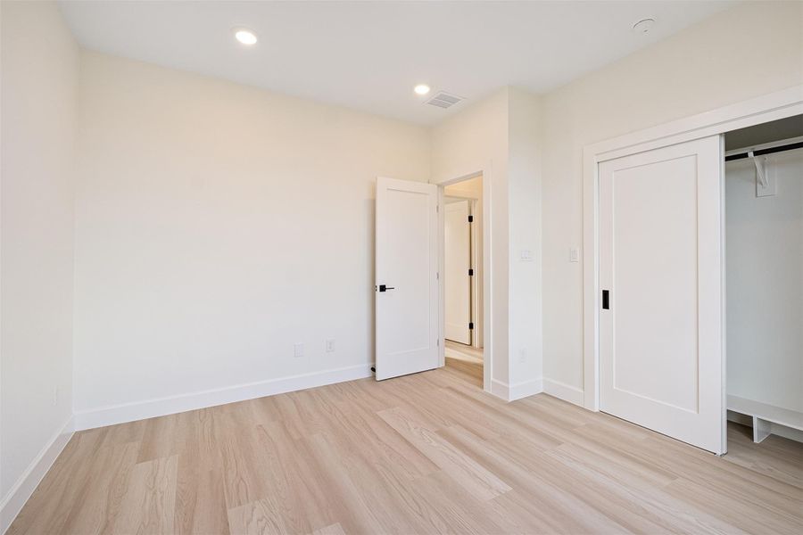 Unfurnished bedroom featuring light wood-style flooring, recessed lighting, and a closet