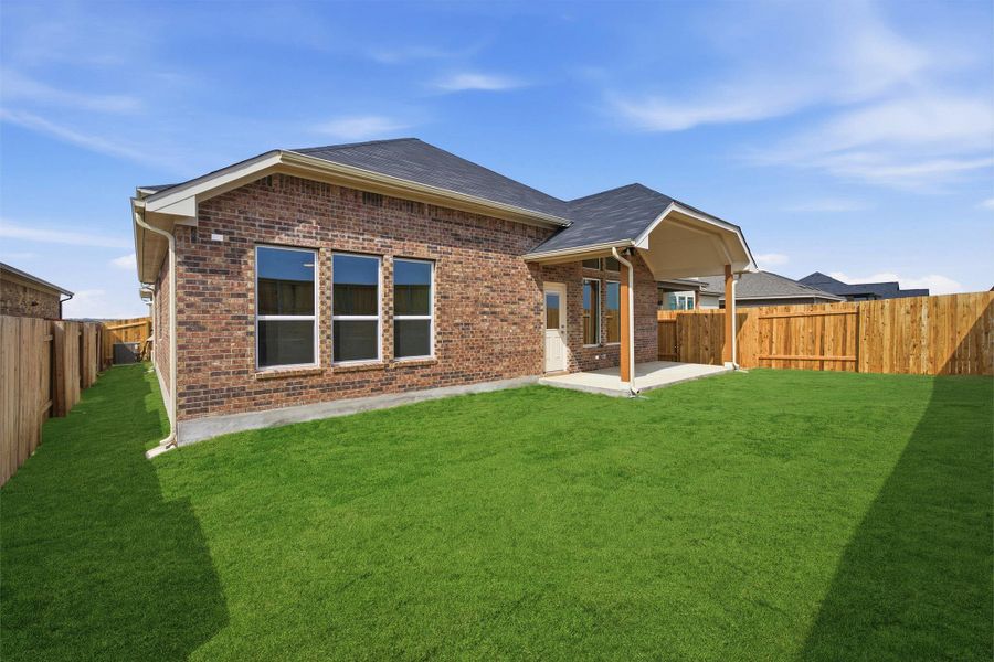 Rear view of house featuring a fenced backyard, a patio, brick siding, and a shingled roof
