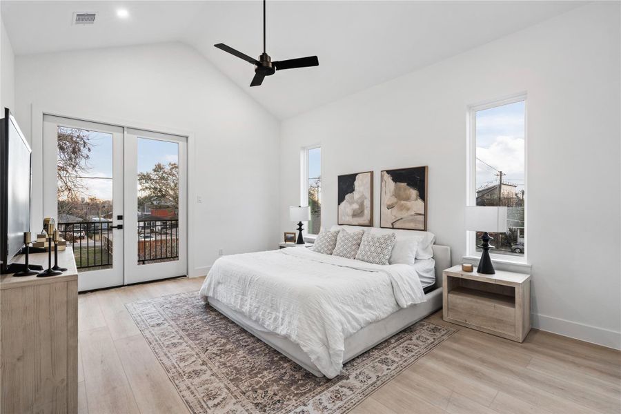 Vaulted ceilings and French doors to a private balcony elevate this serene primary suite, where light and air move effortlessly throughout.