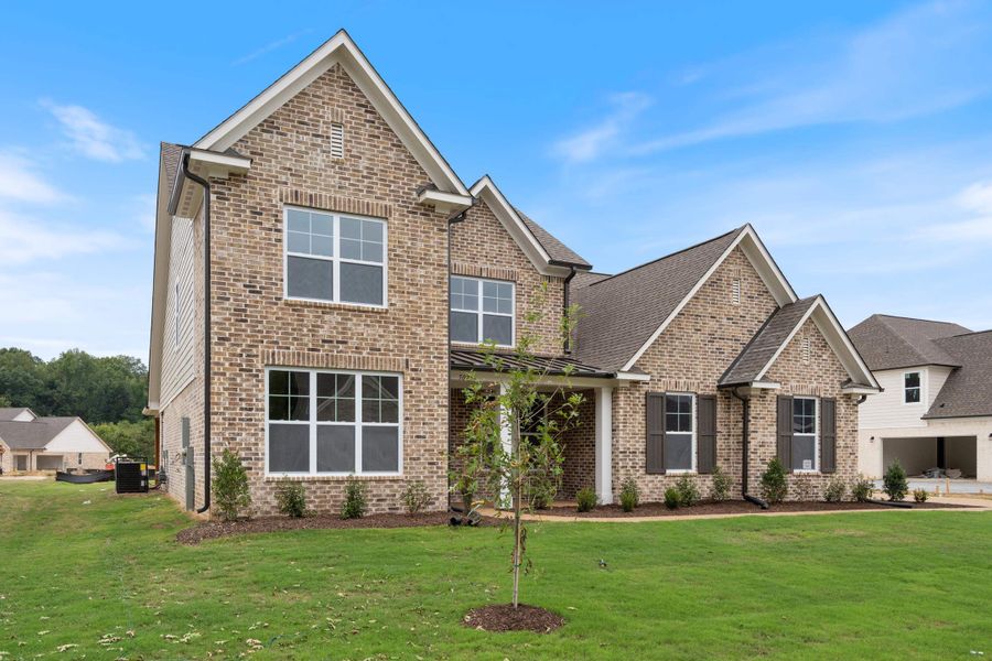 Brick veneer exterior with gabled roof lines, white window trim, dark shutters, and a covered entry Brick veneer exterior with gabled roof lines, white window trim, dark shutters, and a covered entry