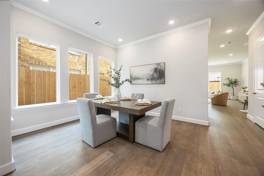 From another angle, the dining room reveals its generous proportions, ready to host your gatherings with grace and doors that open to welcome you home.