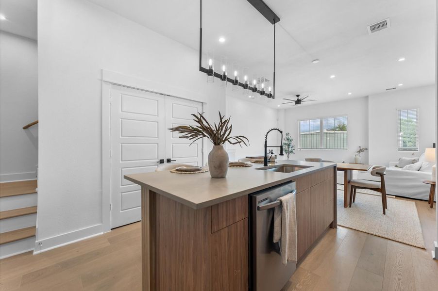 The heart of the second-floor open-concept living, dining, and kitchen, this spacious kitchen island features sleek modern finishes, including a one-sided cascade quartz countertop, a farmhouse sink, and stylish pendant lighting, with a built-in seating area perfect for casual breakfasts or chatting with family and frien The heart of the second-floor open-concept living, dining, and kitchen, this spacious kitchen island features sleek modern finishes, including a one-sided cascade quartz countertop, a farmhouse sink, and stylish pendant lighting, with a built-in seating area perfect for casual breakfasts or chatting with family and frien