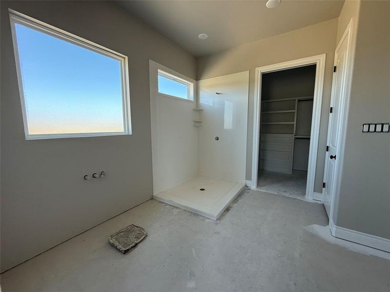 Bathroom featuring walk in shower and a spacious closet