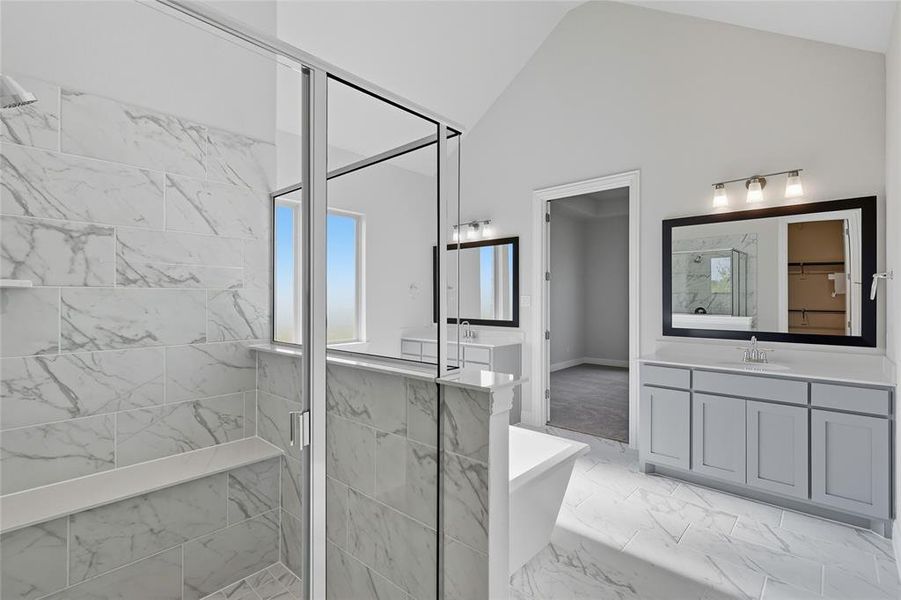 Full bath featuring a marble finish shower, a freestanding tub, vanity, light marble finish flooring, and a spacious closet Full bath featuring a marble finish shower, a freestanding tub, vanity, light marble finish flooring, and a spacious closet