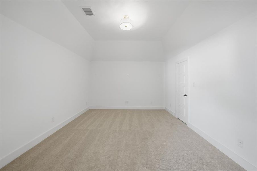 Bonus room with light carpet and baseboards Bonus room with light carpet and baseboards