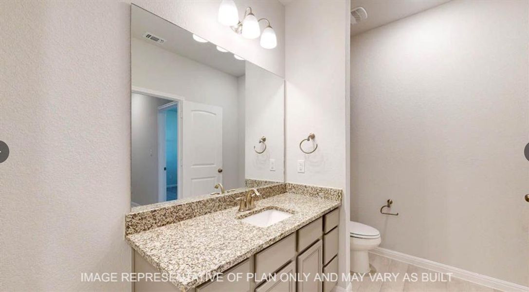 Bathroom with toilet, visible vents, vanity, and baseboards Bathroom with toilet, visible vents, vanity, and baseboards