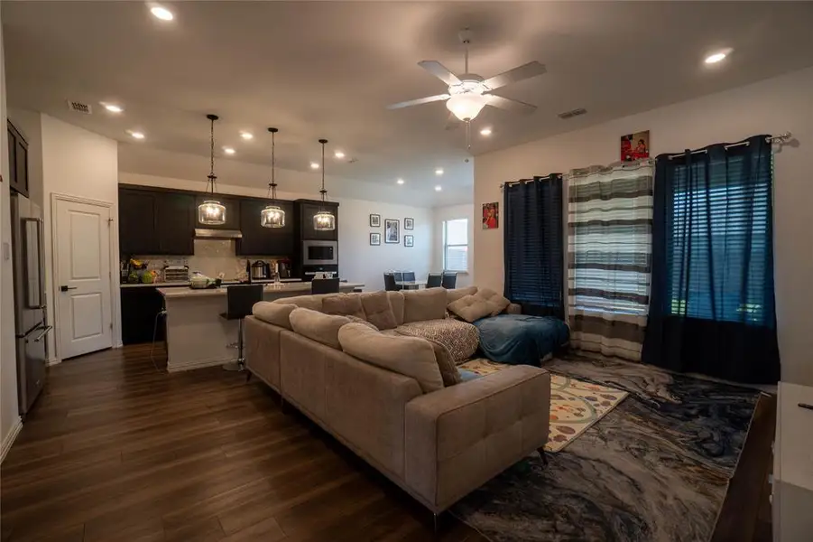 Open-concept living space featuring wood-finish flooring, recessed lighting, and a ceiling fan